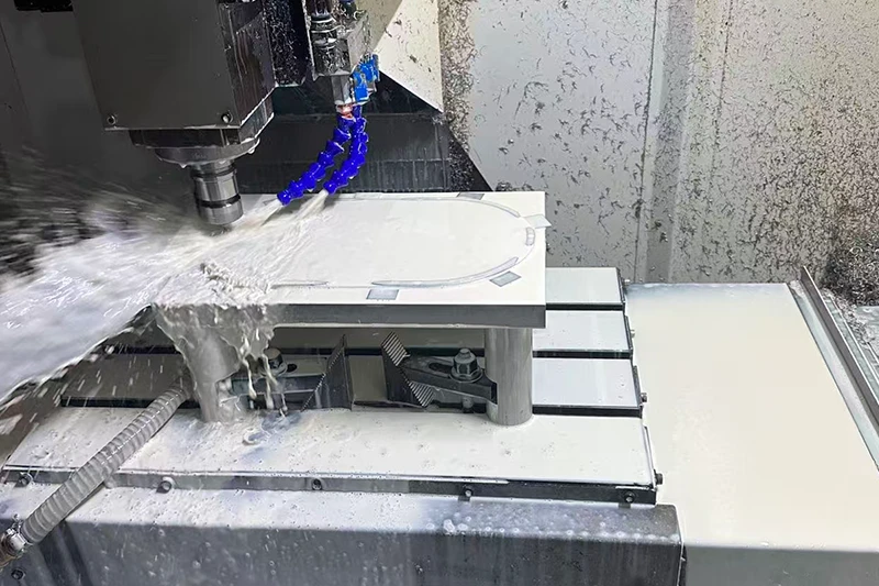 CNC machine milling a part with coolant spray